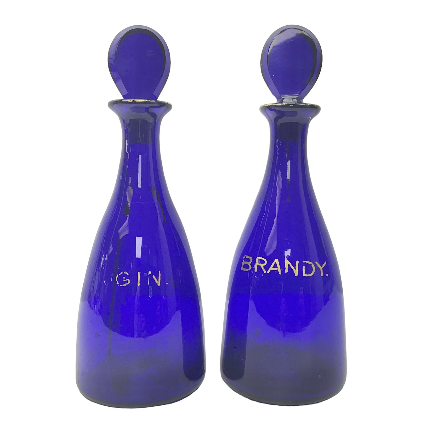 Pair of early 19th century blue glass decanters with teardrop stoppers, with gilt writing, the first marked Gin the second Brandy 
