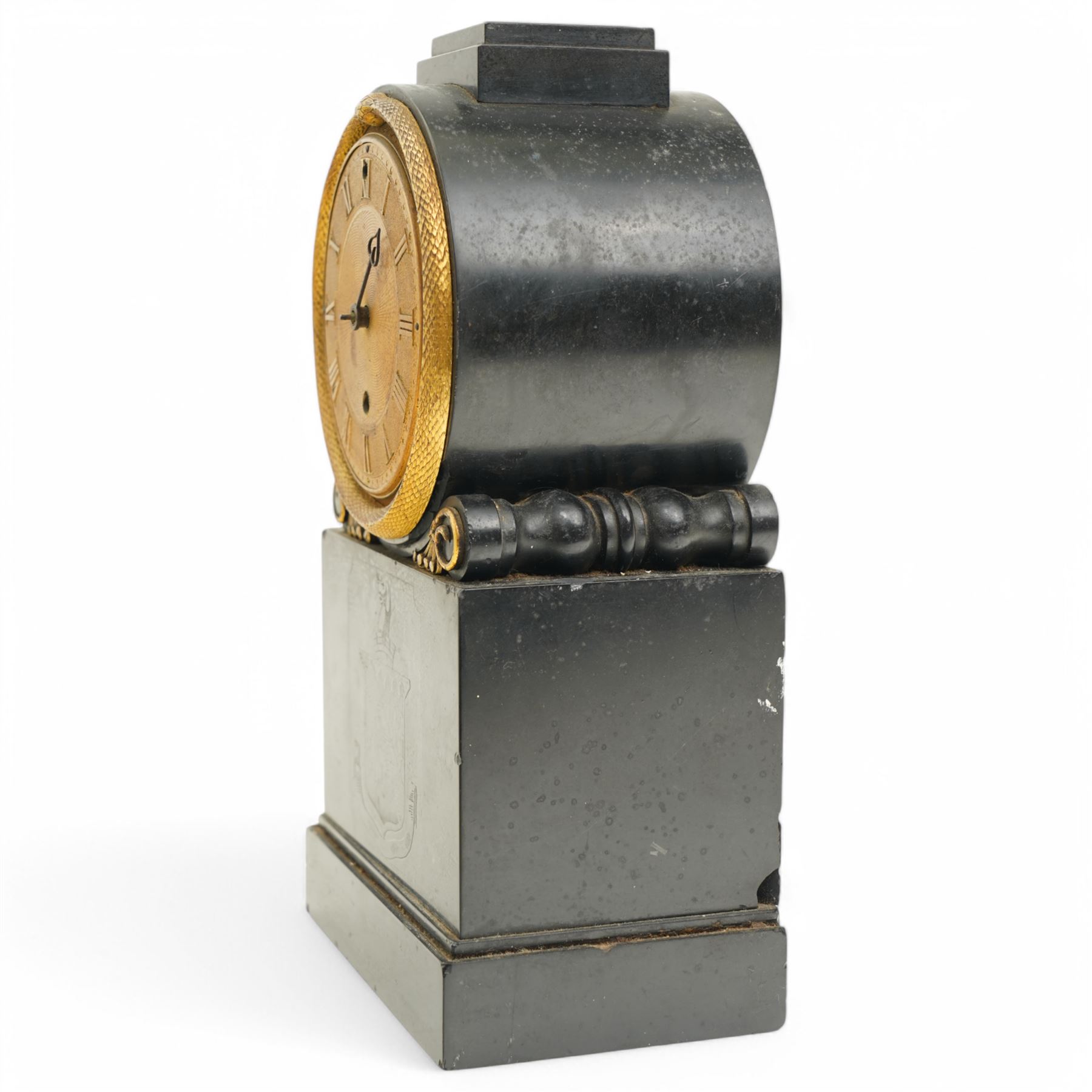 Benjamin Vulliamy of London- a small Regency 8-day ormolu and black marble mantle timepiece c1820, circular movement with a drum housing cradled on decorated scroll supports and a stepped marble plinth, the front of the plinth faintly incised with an armorial coat of arms, 3-1/2