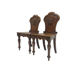 Pair Victorian oak hall chairs, scallop shaped back with carved scrolls and central shield moulding, panel seat over shaped frieze rail, raised on turned supports