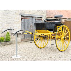 J. W. Thompson Dog Cart

A black and yellow painted two wheeled dog cart with elevated upholstered seat for two, buttoned black leather cushions, high back rail, folding front footboard, louvred sides, side steps, rear drop-down tailboard with chain stays, internal storage compartment, wooden spoked wheels, rubber tyres and shafts for a single horse. The wheel hubs are marked J W Thompson

Dimensions:
Overall length: 366 cm
Width: 160 cm
Height: 190 cm

Wheel Diameter:
Wheels: 139 cm

Seating:
Driver and passenger: 2