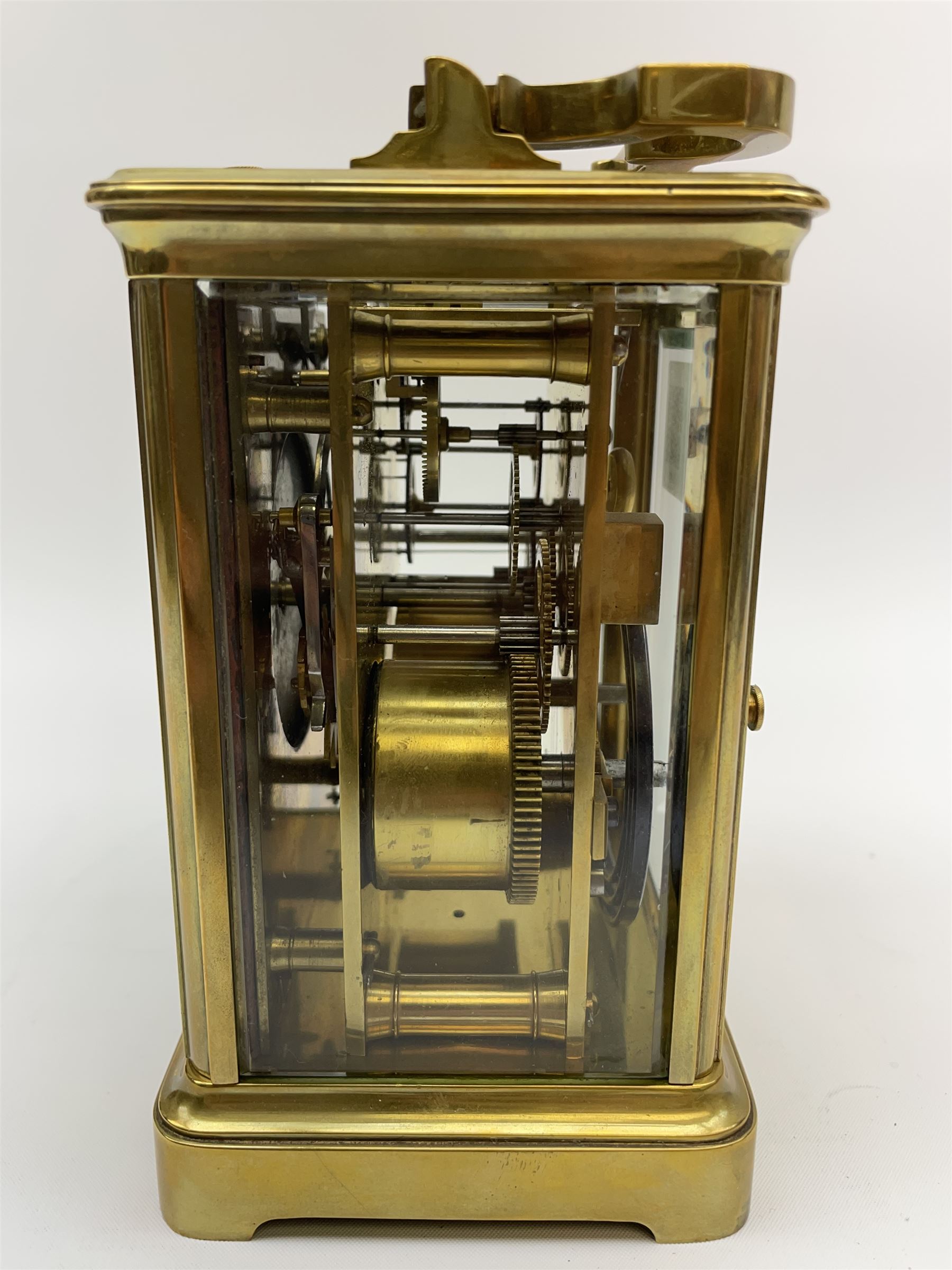 Early to mid 20th century French brass and bevelled glass cased carriage clock, the shaped loop handle over oval glass panel, white enamel Roman dial, twin train driven eight day movement striking on coil, with button push repeater, the movement back plate stamped for 'R & Co.'