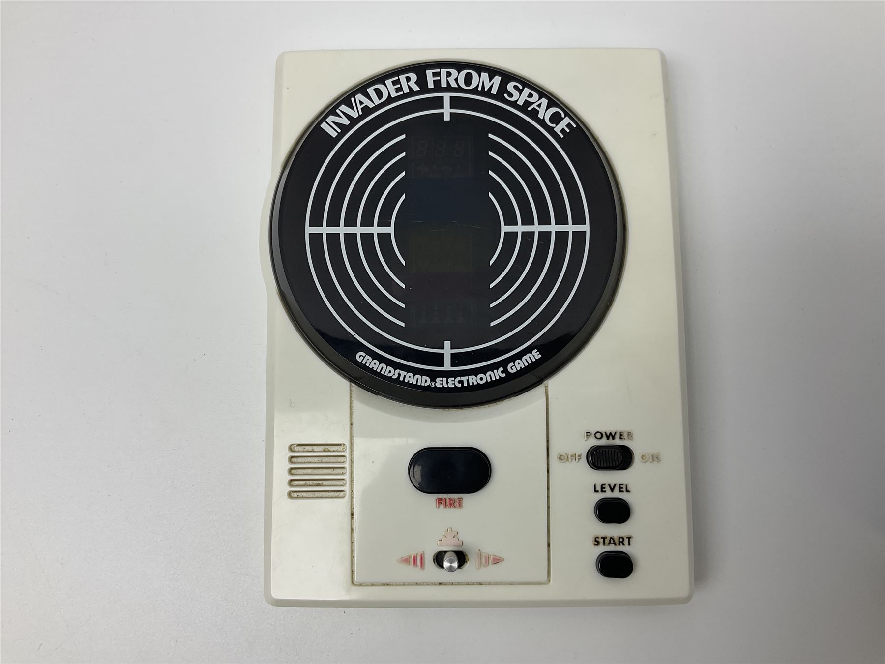 Three late 70s/early 80s handheld electronic games; Bandai Electronics Arcade ‘Gunfighter’ (1980), Grandstand ‘Invader From Space’ (1980), Palitoy ‘Merlin The Electronic Game Machine’ (1979) with game sheet and instruction booklet, all with original boxes (3) 