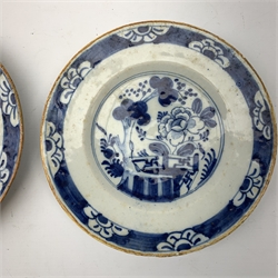 A pair of late 18th century/early 19th century blue and white Delft plates, of circular form decorated with blossoming trees and flowers, within foliate borders, D23cm. 
