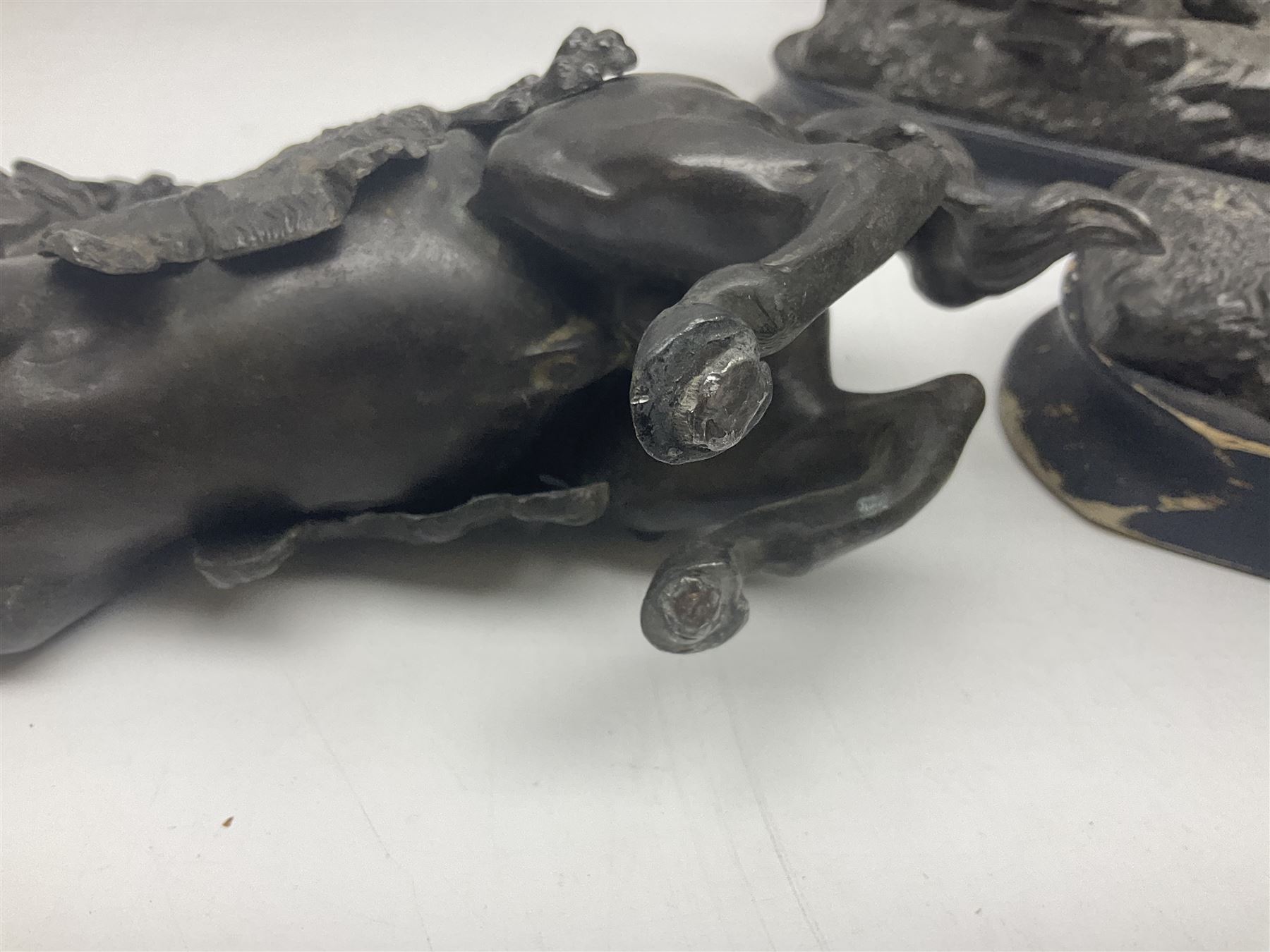 Spanish carved figure of Don Quixote, holding a book, base stamped 'Ouro, together with two spelter figures and one other