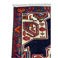 North West Persian Heriz rug, blue and ivory ground, decorated with stylised plant motifs, the border decorated with repeating geometric design 