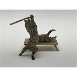 After Bergmann, two cold painted bronze figures, the first modelled as two cats on a bench hugging, the second a cat caning a kitten