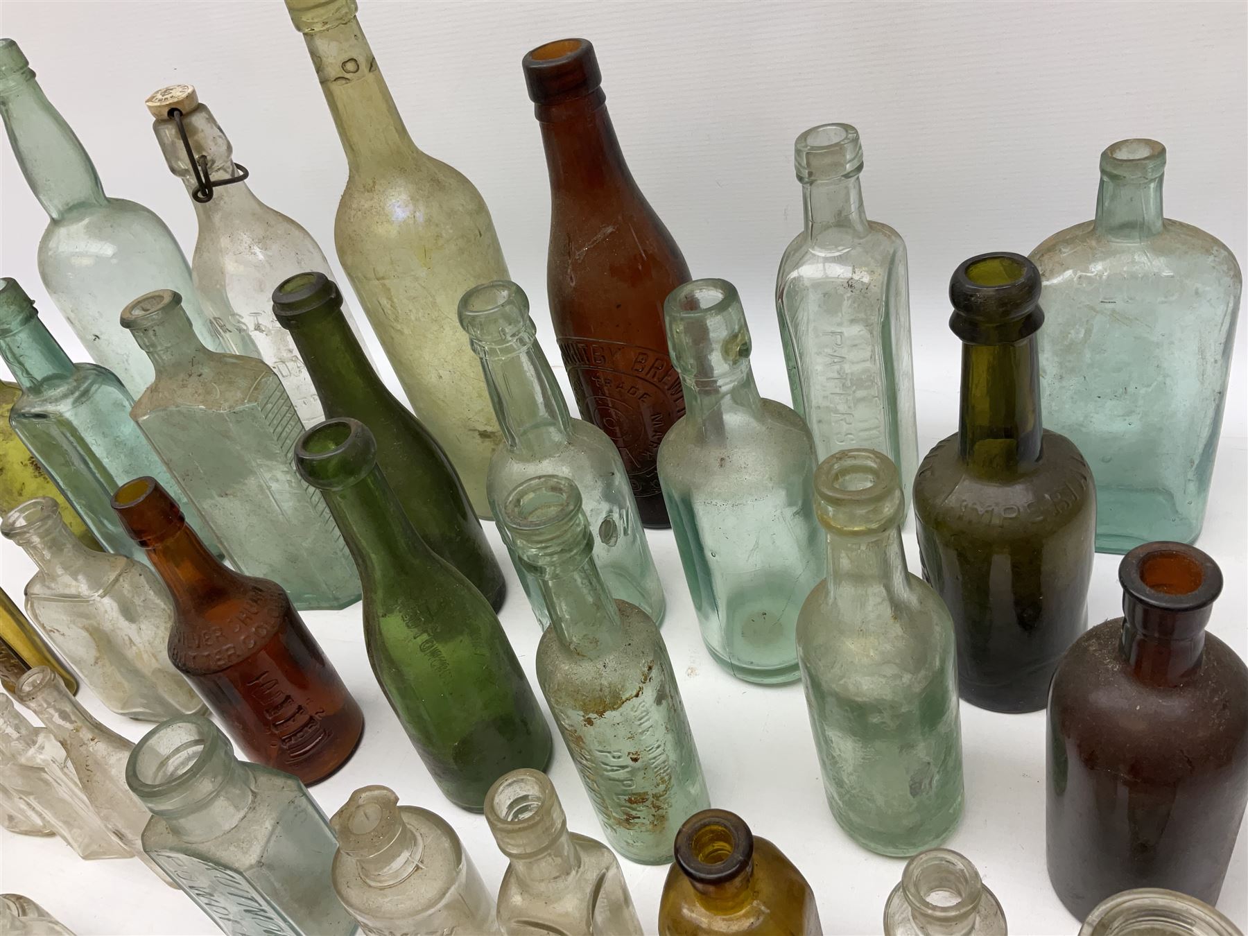 Collection of various vintage glass bottles and stoppers, including advertising bottles, sauce bottles and medical bottles etc