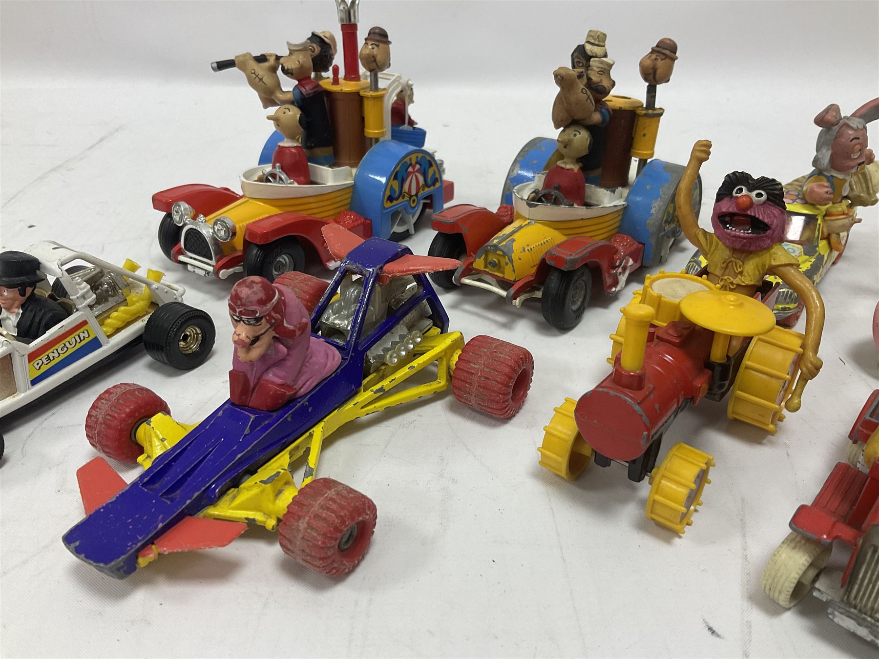 Corgi - ten unboxed and playworn TV/Film related die-cast models including three Popeye Paddle Wagons; Dick Dastardly; Magic Roundabout; Muppets; Batman Penguinmobile; and Basil Brush (10)