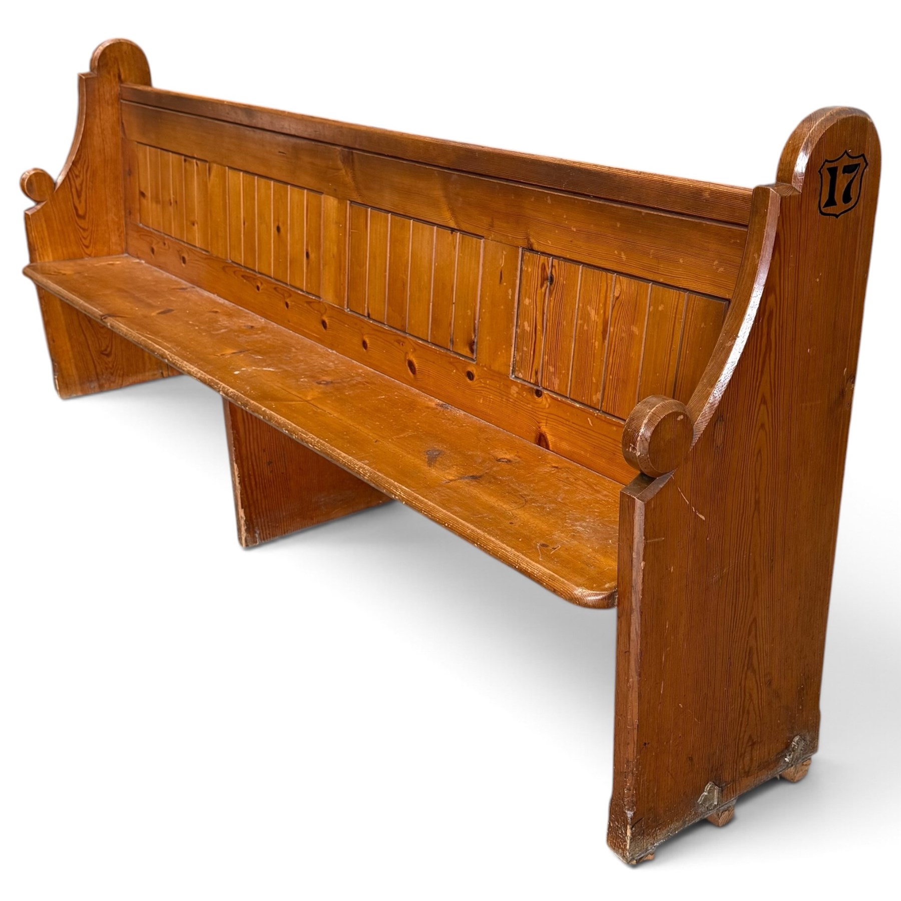 Early 20th century stained pine ecclesiastical church pew, the shaped end supports flanking slatted and panelled back, with black stencilled number '17' to the side