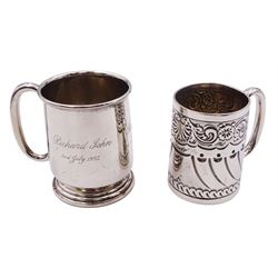 Late Victorian silver christening mug, of tapering cylindrical form with C handle, embossed with part fluting, flower heads and scrolls, hallmarked Atkin Brothers, Sheffield 1898, H7cm, together with a mid 20th century silver christening mug, with C handle and engraved dedication to body, upon a stepped circular foot, hallmarked Joseph Gloster Ltd, Birmingham 1955, H8cm, approximate total weight 5.63 ozt (175 grams), (2)