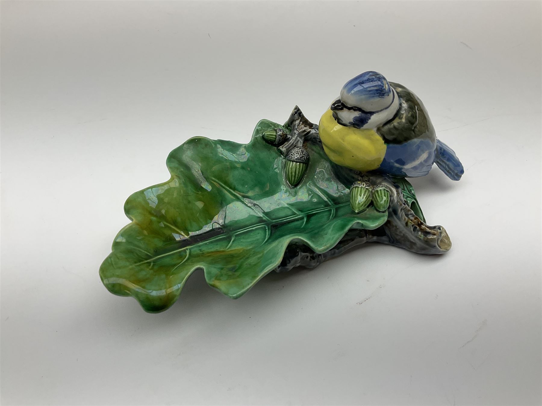 Minton majolica leaf dish, modelled as a Blue Tit perched on a branch with acorns and an oak leaf, date cypher for 1868, impressed marks beneath, L21cm. 