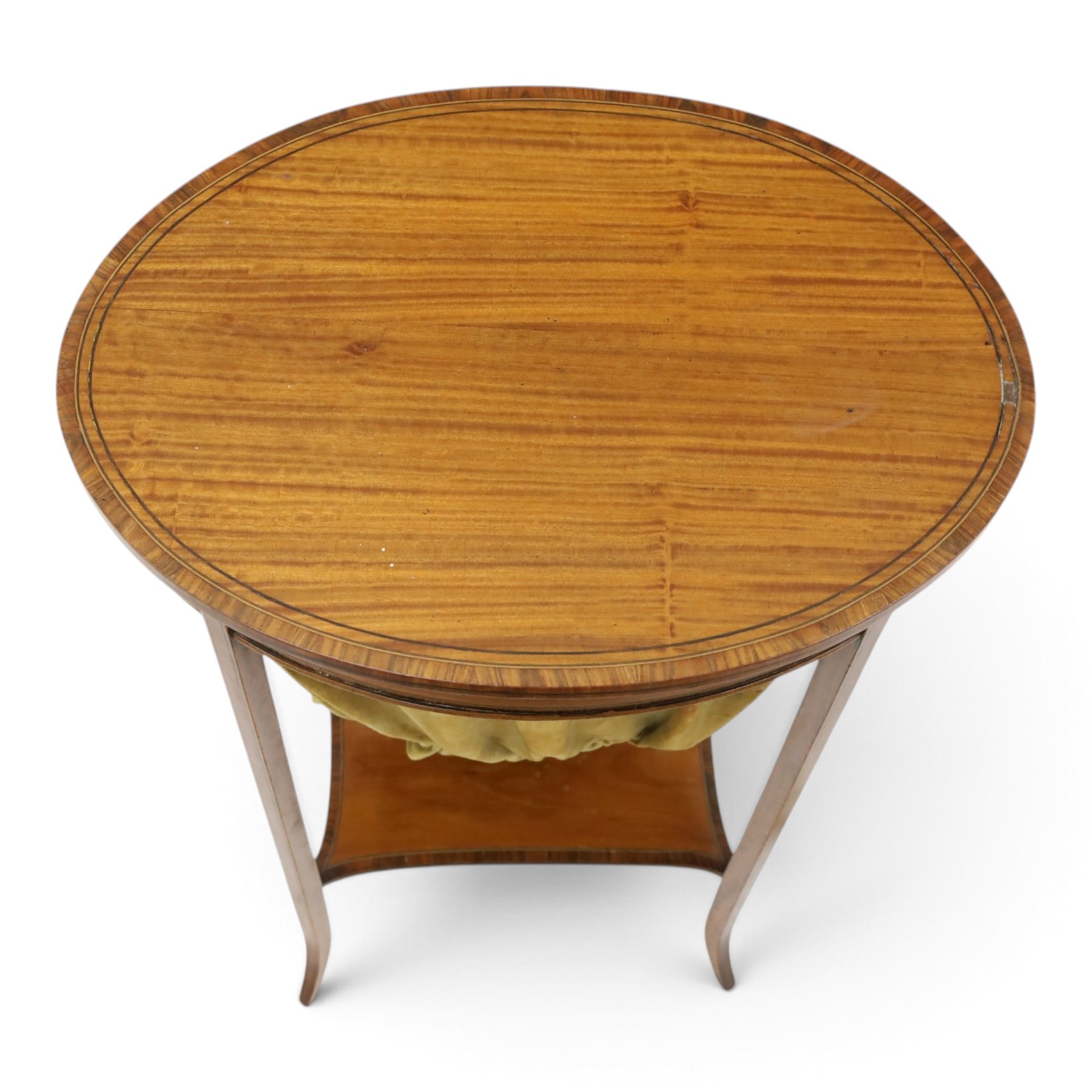 Edwardian inlaid satinwood oval sewing or work table, crossbanded and ebony-strung hinged top enclosing fitted compartment and olive-green upholstered well, raised on square tapering splayed supports united by under-tier 