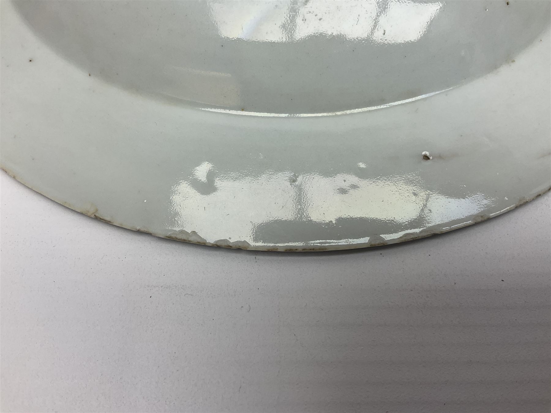 Three 18th century Chinese Famille Rose plates, the first example enamelled with blossoming peonies, rockwork and fence, the other two examples of similar design, decorated with blossoming peonies and sprigs within shaped inner borders, each approximately D23cm