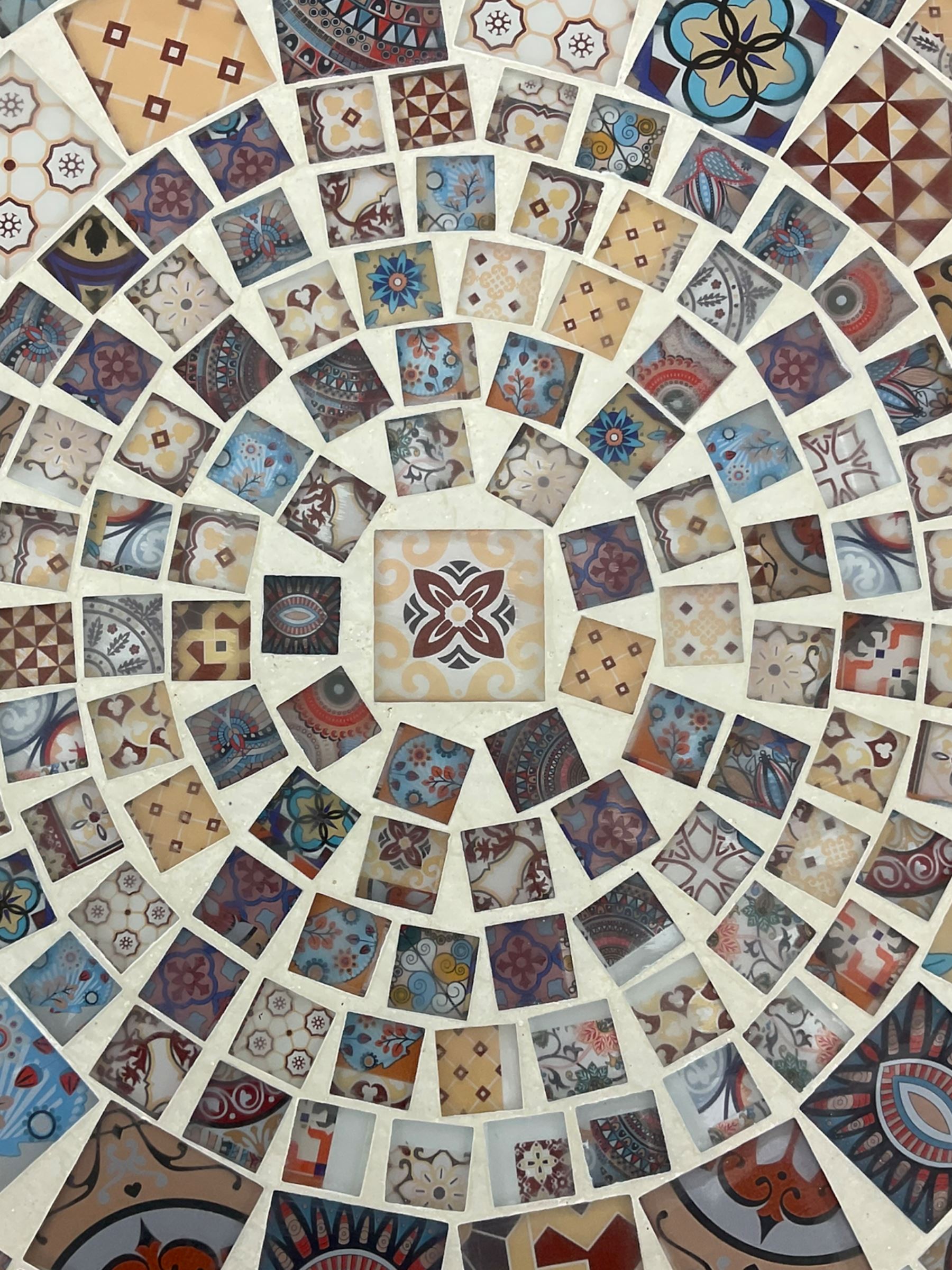 Black painted metal bistro set, circular table with mosaic top, and pair of folding chairs with mosaic panels 