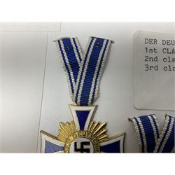 WWII set of three German Mother's Crosses, 1st Class in gilt, 2nd Class in silver and 3rd Class in bronze; all with ribbons (3)