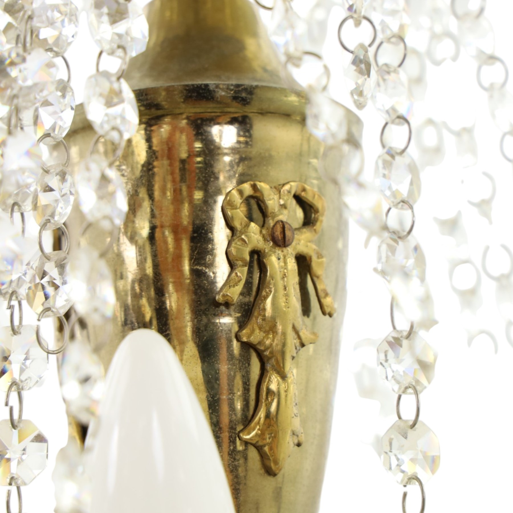 Empire design brass and crystal chandelier, the two circular brass tiers with foliate mounts, connecting the cascading crystal garlands, with prismatic drops