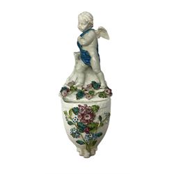 Victorian wall pocket by Moore Brothers retailed by T.Goode modelled as a semi nude white glaze cherub with turquoise ribbon, with encrusted floral decoration, the reverse stamped ‘T.Goode & Co.’, H32cm