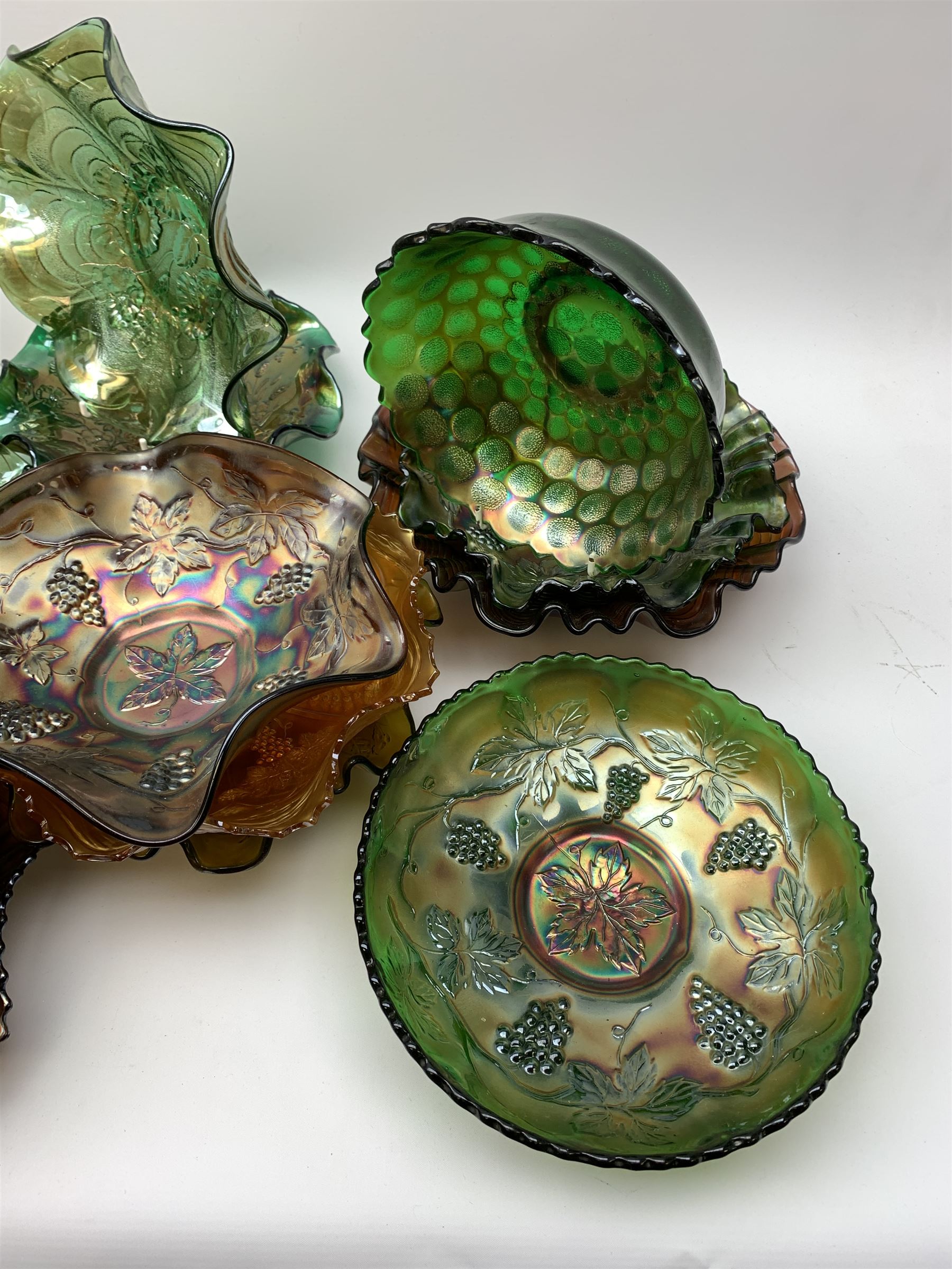 A collection of Carnival glass, to include marigold, green, and amethyst, bowls, dishes, and comports, various patterns including fruiting vines, peacocks, and an example decorated with a Horseshoe and detailed Good Luck. 
