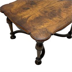 Figured mahogany coffee table, shaped moulded top with oval book-matched veneered panels, on turned supports united by waved X-shaped stretchers 