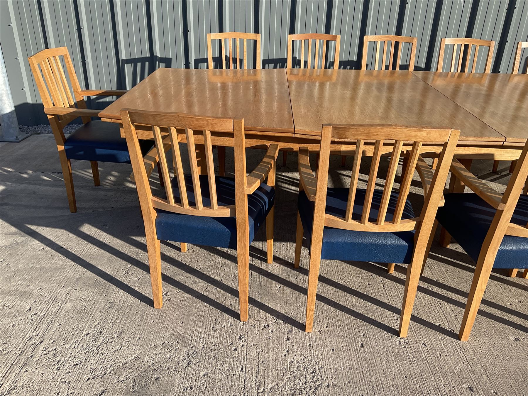 Light oak bespoke boardroom table, concave form, four sectional top on square discreet legs (12' x 5'), with twelve armchairs including 'Chairmans' chair