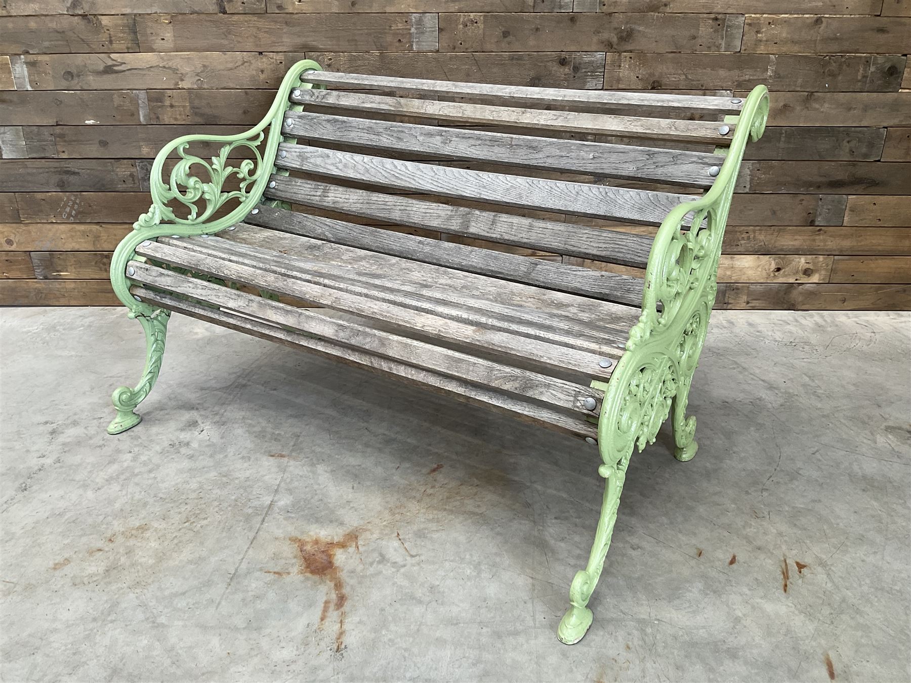 Early 20th century ornate green painted cast iron and hardwood slatted garden bench