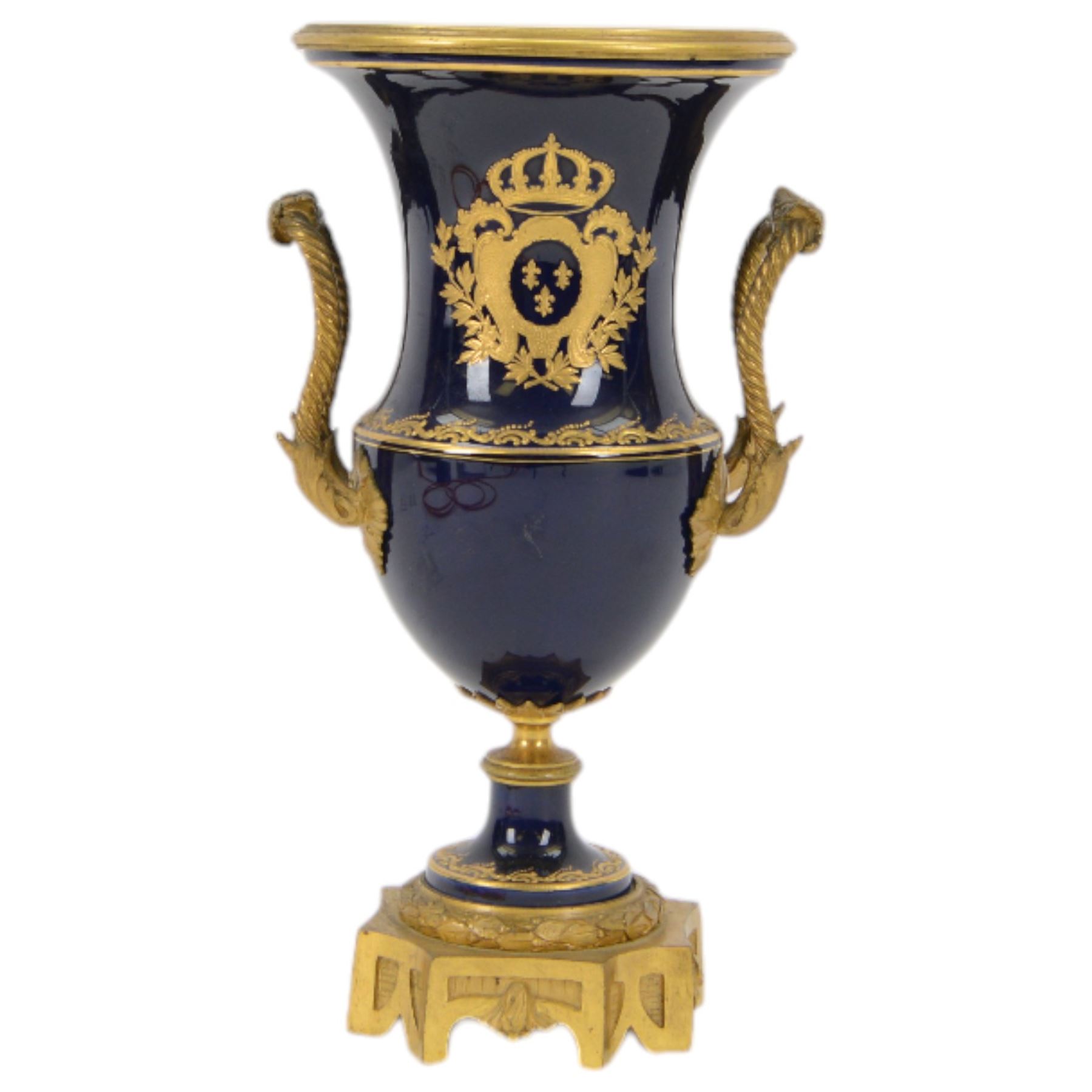 19th century Sevres style ormolu mounted porcelain twin handled urn, the body decorated with a gilt crowned crest of three fleur de lis against a cobalt ground, with spurious Sevres mark beneath, H26cm
