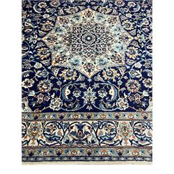 Persian Nain indigo and ivory ground rug, central pointed medallion within a field of scrolling branch and stylised floral motifs, repeating scrolled border with stylised plant motifs