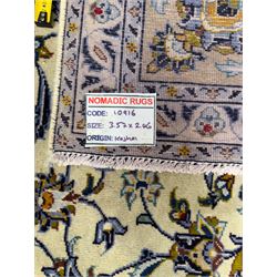 Central Persian Kashan hand-knotted carpet, ivory field with an all-over design of scrolling vines, lotus palmettes, and rosettes in shades of blue, gold, and brown within a blue ground border of palmettes and arabesques between multiple guard stripes