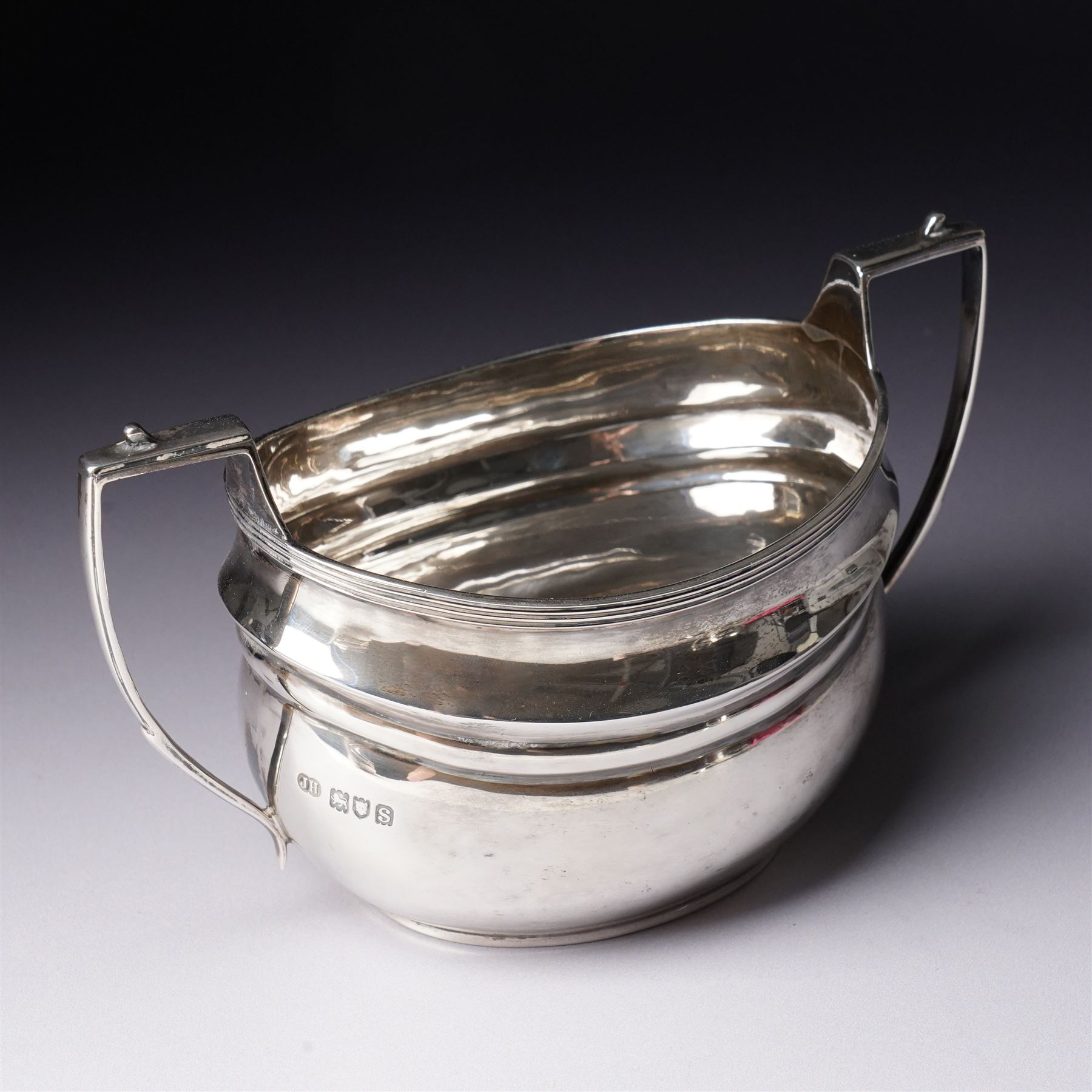 Silver three piece tea set of oval form, the teapot with ebonised handle and lift London 1913 Maker John Hunt and a pair of Victorian silver sugar tongs