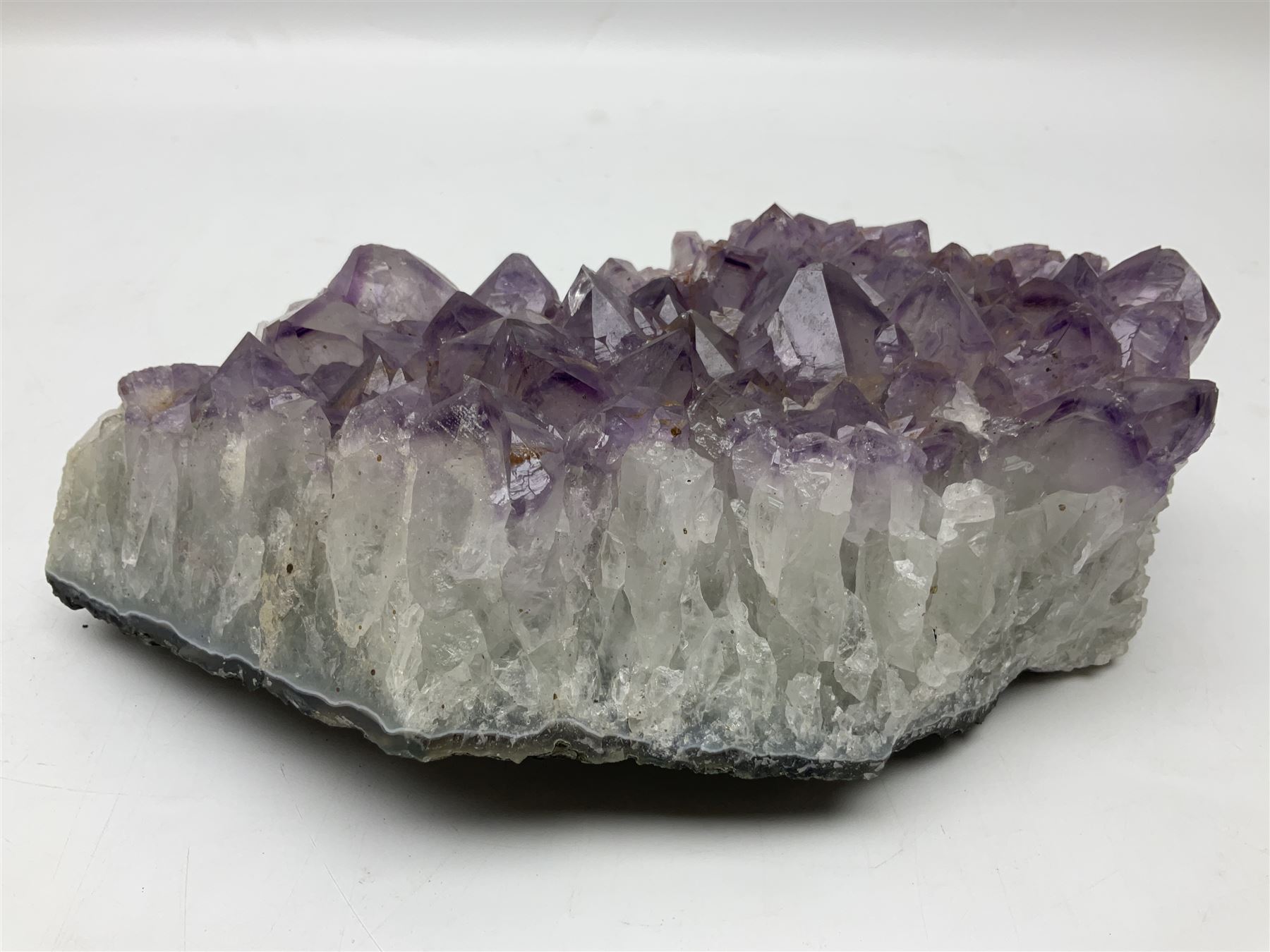 Amethyst crystal geode cluster, with well-defined crystals of various sizes, H10cm, L30cm