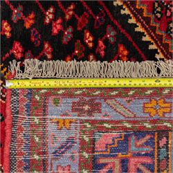 North west Persian Koliahee hand-knotted rug, central magenta field with elongated hexagonal medallion and arrow-shaped pendants over a dark lozenge-filled panels and stepped spandrels filled with boteh and floral motifs, corner square and cruciform devices within a pale olive border of stylized rosettes and angular vines between narrow guard stripes 