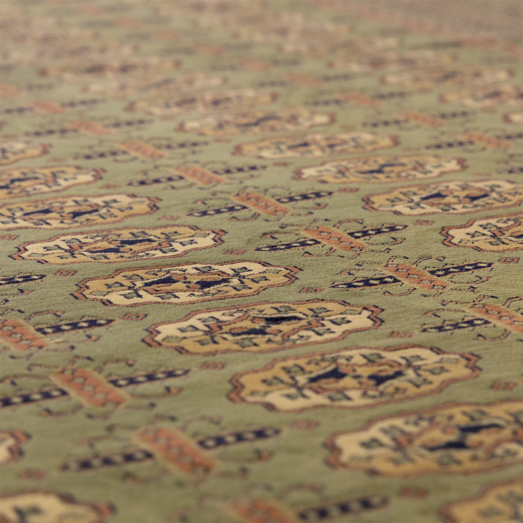Turkish Bokhara design rug, olive green field decorated with an all-over design of repeating gul motifs arranged in rows, enclosed by a series of narrow and wide geometric borders with diamond and star devices 