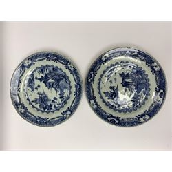 Set of eight late 18th/early 19th century Chinese export blue and white plates, of circular form decorated with landscape set with two figures upon a bridge, waterside huts and boats, within spearhead and foliate and stylised key border, D23.5cm