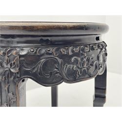 Early 20th century Chinese padauk wood jardiniere stand, circular top with red marble inset, the frieze relief carved with scrolling foliage, plain supports with carved paw feet