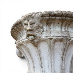 Pair of Neoclassical design cast stone garden urns, each of campana form with fluted body and gadrooned underbelly, decorated with faun/satyr opposing masks and ropetwist handles, with floral and mask design to the socles, raised on square bases, finished in weathered white patina