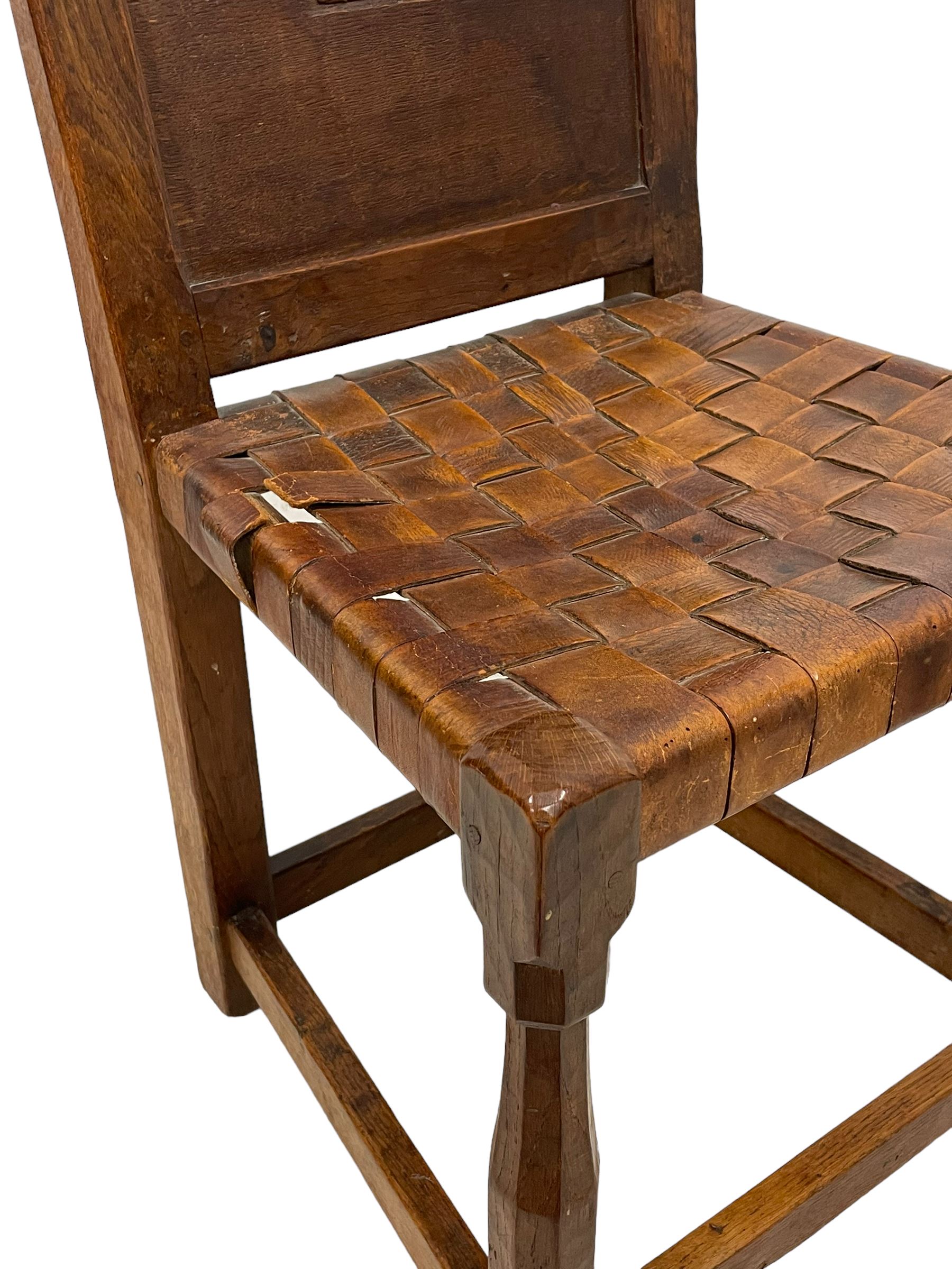 Mouseman - circa. 1930s set of six (4+2) oak dining chairs, panelled back carved with the Bagshawe family crest, the moto 'Forma Flos Fama Flatus' over an arm grasping a bugle-horn with ribbon tie and Yorkshire rose motif, adzed frame, leather lattice strap seat, on octagonal supports united by stretchers, two carvers and four side chairs, each carved with mouse signature, by Robert Thompson of Kilburn 

Provenance: Owned since manufacture by the Bagshawe family, descendants of the Staithes Group Artist Joseph Richard Bagshawe RBA (1870-1909).