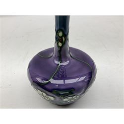 Three Minton Secessionist vases, with tube-lined stylised flower decoration, two upon a red ground and third upon a purple ground, all with printed mark to base 'Minton Ltd, No. 33', H13cm