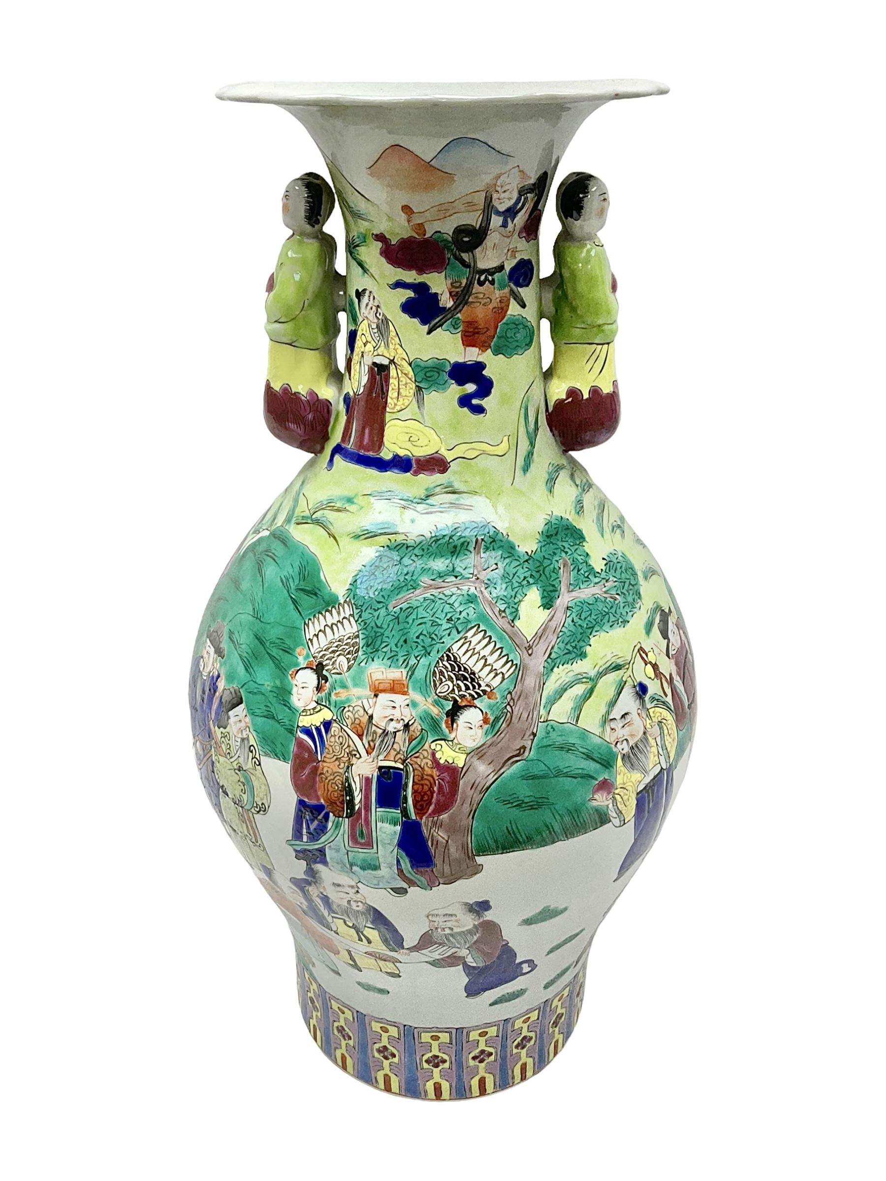 20th century Chinese Famille Rose vase, of baluster form with flared lobed rim and twin figural handles, decorated in polychrome enamel with figures dancing and playing instruments within a garden setting, H42cm