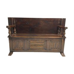 Jacobean design oak Monks bench, the front with carved linenfold panels, hinged metaphoric table back, hinged box seat compartment, on sledge feet
