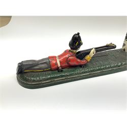 Very rare 19th century John Harper & Co. mechanical cast-iron money box, registered number 33821 patented 1885, inscribed on metal plaque 'Wimbledon Bank', based on the Queen's Trophy for shooting at Wimbledon, depicting a British Infantry man in red tunic and blue trousers lying on the ground using a gun to fire a brass coin launcher into a pill box with removable moving flag above L30cm