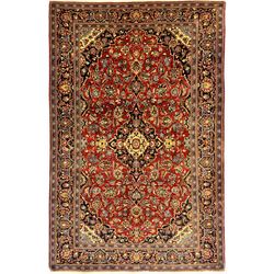 Central Persian Kashan crimson ground rug, central indigo pole medallion surrounded by sparsely placed bouquets interconnected with foliate branches, the guarded border with repeating palmette and Boteh motifs with interwoven scrolling patterns, framed by guard stripes