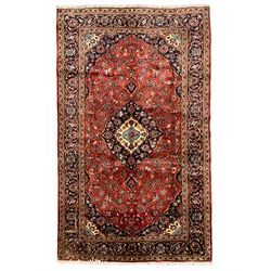 Persian Ardakan crimson ground rug, the field with shaped floral design medallion surrounded by curled leafy branches, scrolling border with stylised plant motifs