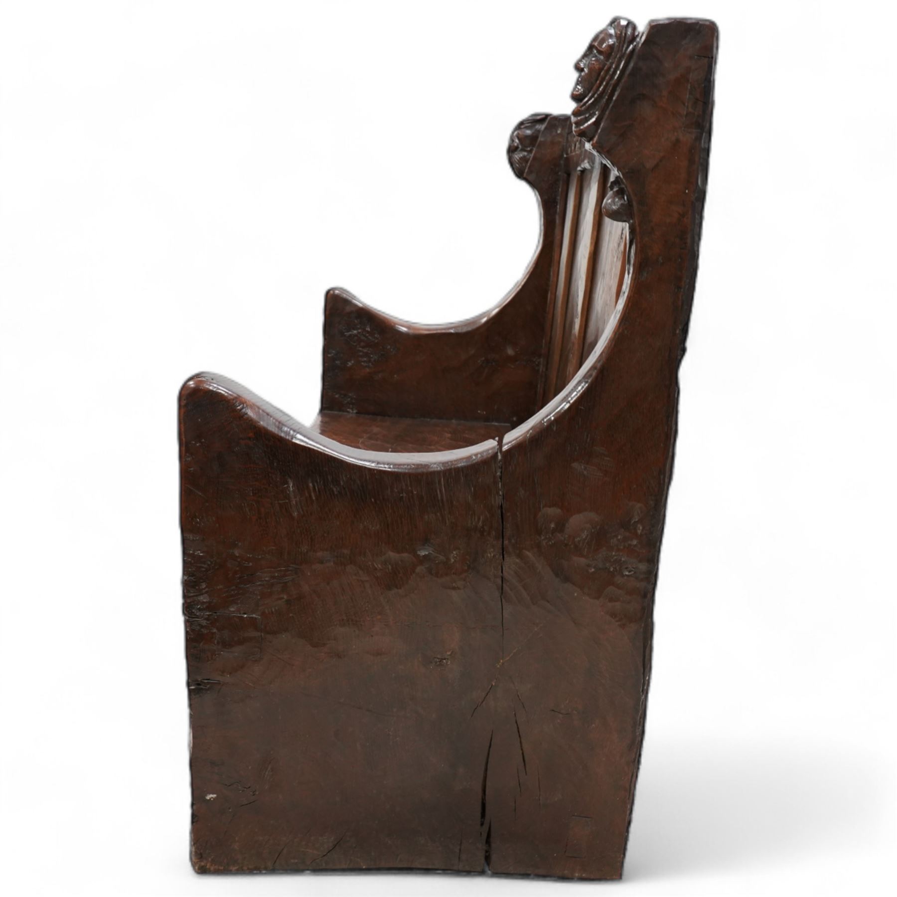 Mouseman - circa. 1920s adzed oak settle or bench, the cresting rail carved with inscription 'Before Honour is Humility', four panel back and plank seat on shaped end supports carved with grotesque masks terminals, carved with mouse signature, by Robert Thompson of Kilburn 
