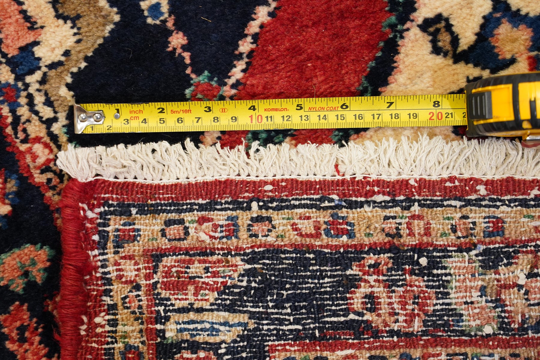 Persian Hamadan runner rug, the vermilion ground decorated with a row of ivory and indigo medallions interspersed with stylised flowering plants, indigo spandrels, enclosed by an indigo floral border and narrow patterned guard stripes