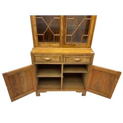 Acorn Industries - Georgian design yew bookcase on cupboard, fitted with two astragal glazed doors enclosing three glass shelves, over two drawers and cupboards, carved acorn signature to side, by Alan Grainger of Brandsby