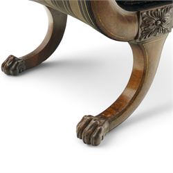 Regency brass inlaid rosewood chaise lounge or settee, shaped back over rolled head and foot, upholstered in black and gold striped fabric with rectangular squab cushion and bolster cushion, the rolled terminals carved with acanthus leaf roundels, lower rectangular foliate carved panels, on out splayed supports with paw carved feet 