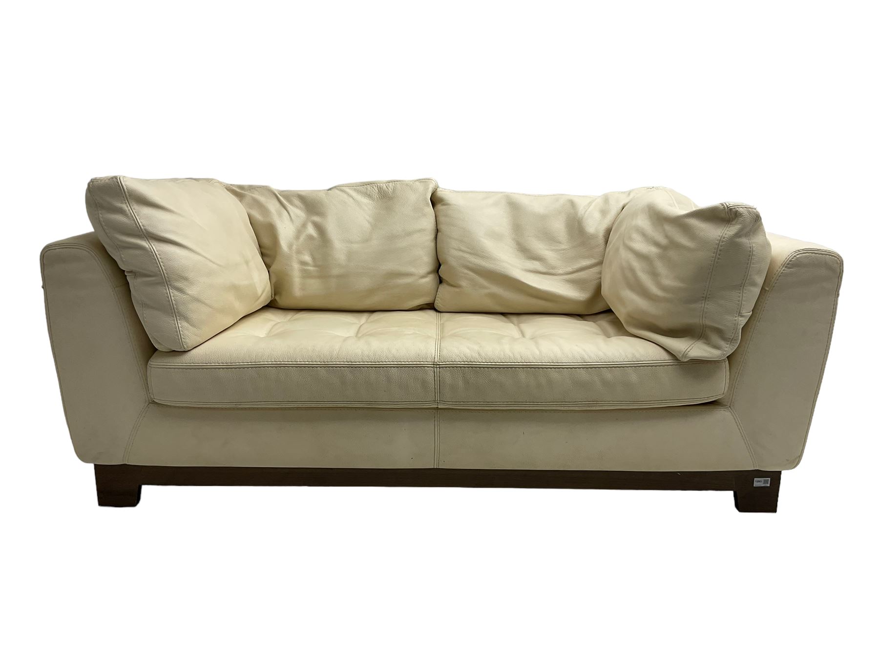 Roche-Bobois - two seat sofa, upholstered in ivory leather with buttoned seat cushions, raised on a stained beech base with bracket feet