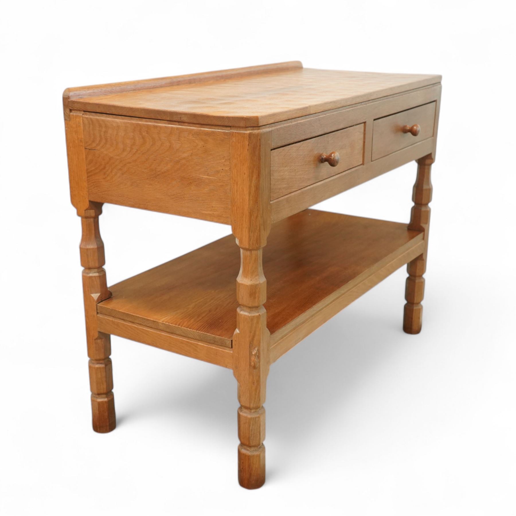 Mouseman - oak side table or buffet, raised back over rectangular canted adzed top, fitted with two drawers, raised on four octagonal turned supports united by undertier, carved with mouse signature, by the workshop of Robert Thompson, Kilburn 