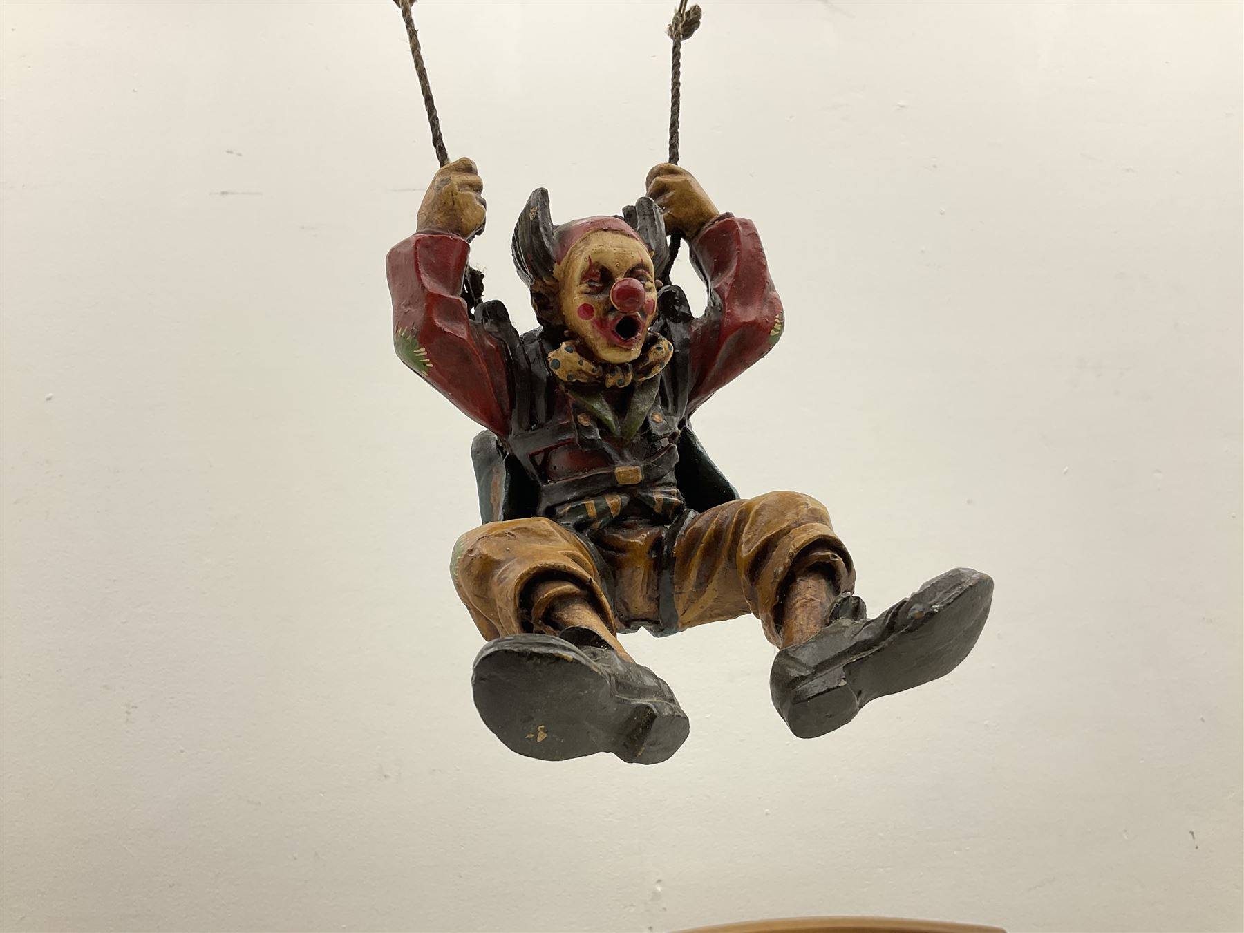 Painted wooden hanging model of a hot air balloon group, the balloon above a wicker basket complete with sandbags and figures, together with a similar example with a clown figure below, H68cm