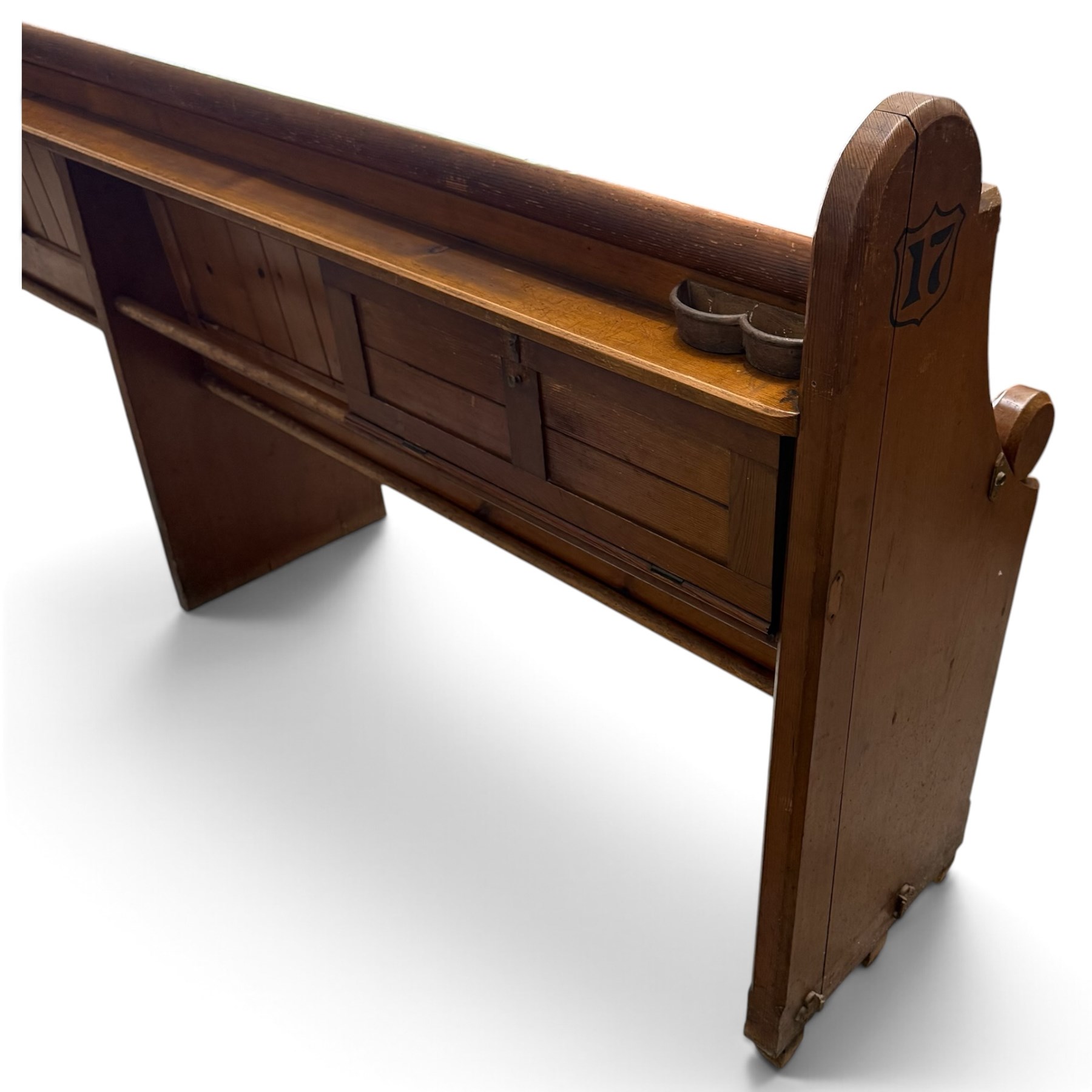 Early 20th century stained pine ecclesiastical church pew, the shaped end supports flanking slatted and panelled back, with black stencilled number '17' to the side